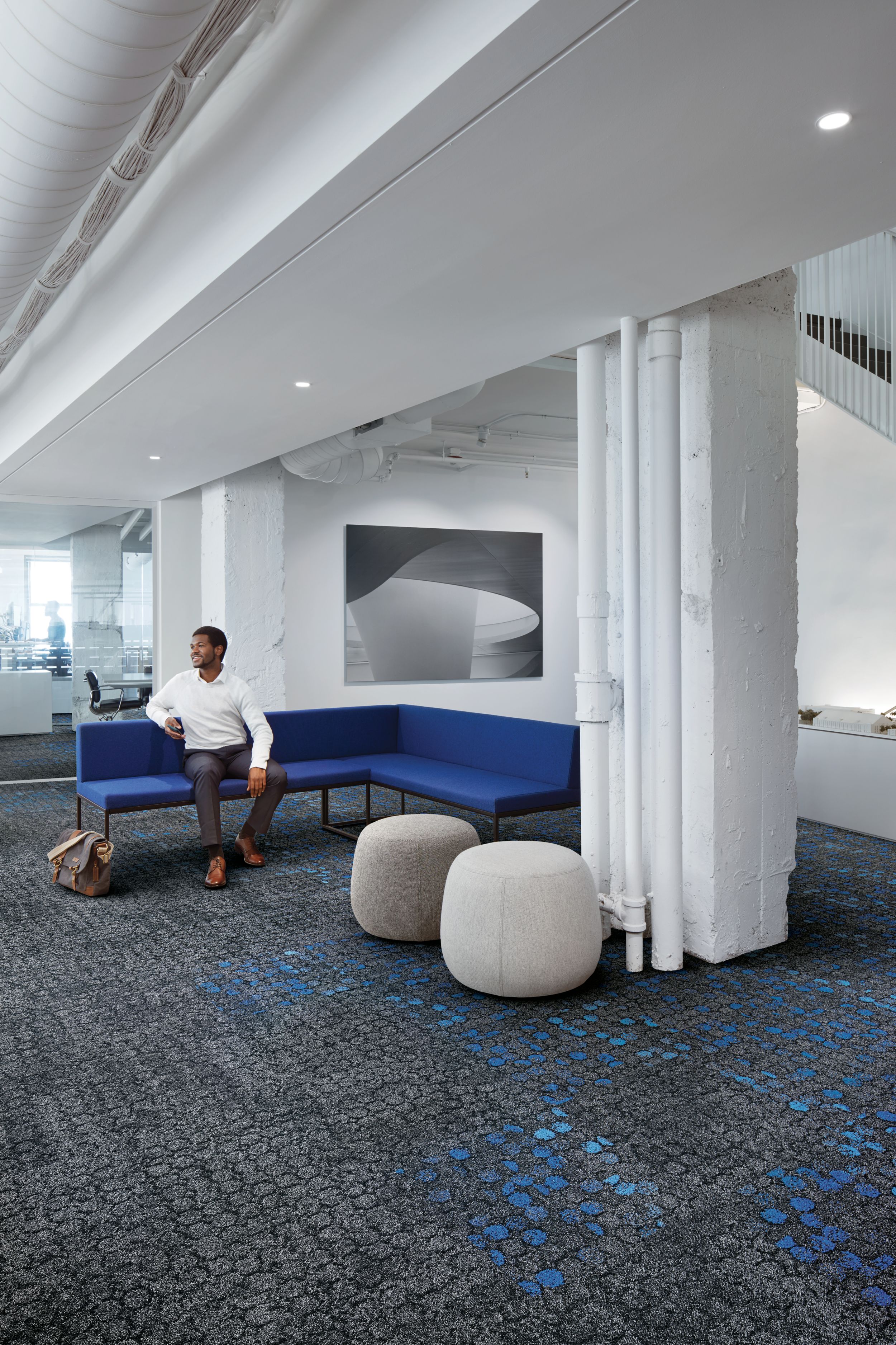 Interface Broome Street and Mercer Street carpet tile in lobby with man seated on blue couch image number 6